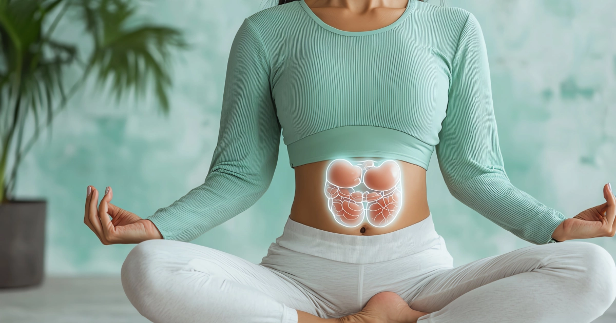 Woman in lotus yoga pose with a glowing intestine diagram superimposed on her abdomen, representing Gut Health in Manchester, NH.